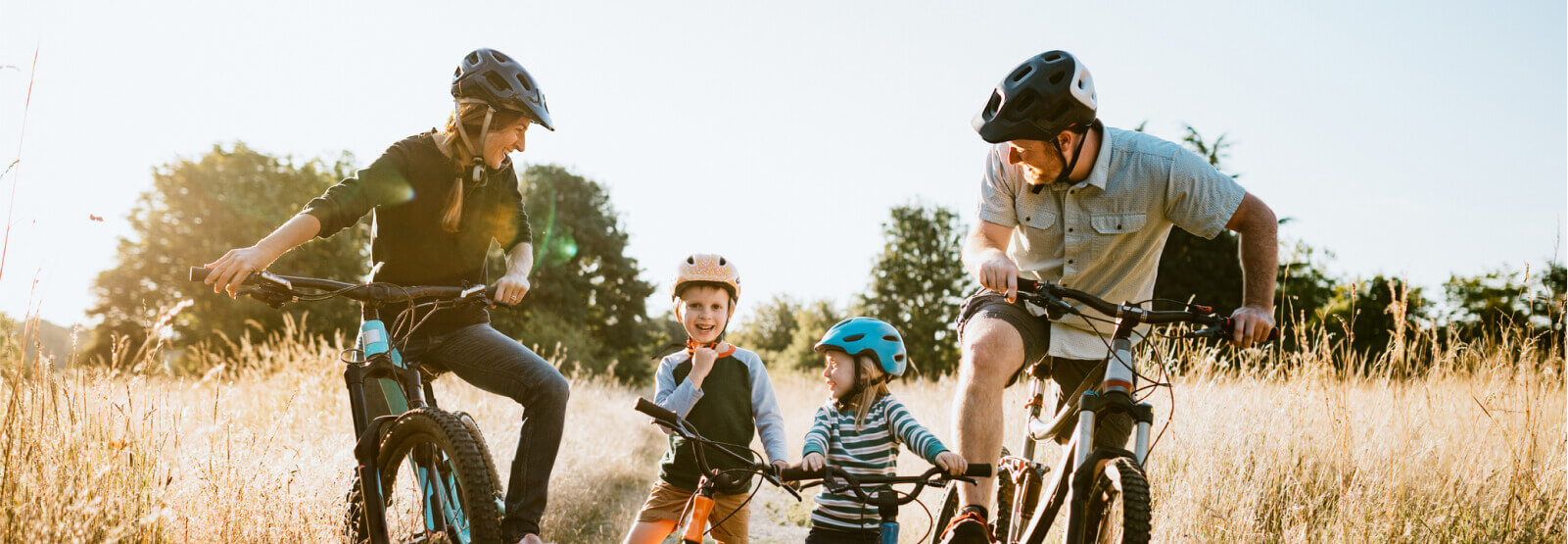 Young family on bikes in a field