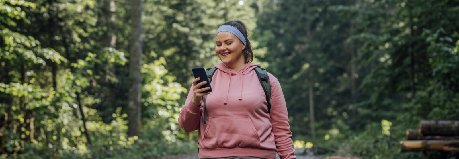 Woman holding a smartphone in a wooded area